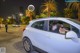 A woman sitting in the driver's seat of a white car.