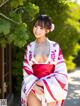 A woman in a red and white kimono posing for the camera.