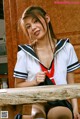 A woman in a school uniform sitting at a table.