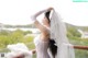 A woman in a wedding dress standing on a balcony.