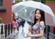 A woman in a floral dress holding an umbrella.