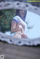 A woman in a white bikini standing in front of a mirror.