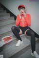 A woman sitting on the steps eating a slice of pizza.