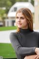 A woman in a black turtle neck top posing for a picture.