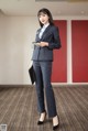 A woman in a business suit standing in a room.