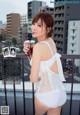 A woman in a white lingerie holding a drink.