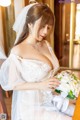 A woman in a wedding dress holding a bouquet of flowers.