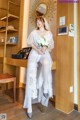 A woman in a wedding dress sitting on a chair.