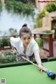 A woman is playing a game of pool. 