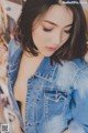 a woman in a denim jacket posing for a picture