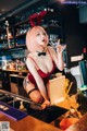 A woman in a bunny costume is pouring a drink at a bar.