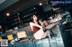 A woman sitting on a bar stool in a restaurant.