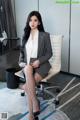 A woman sitting on a chair in an office.