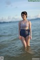 A woman in a bathing suit standing in the water.